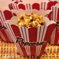 Red Stripe Party Bag filled with Bacon Bourbon Caramel Popcorn. Bacon, Maple Syrup and Kentucky Bourbon make the Popcorn irresistible.